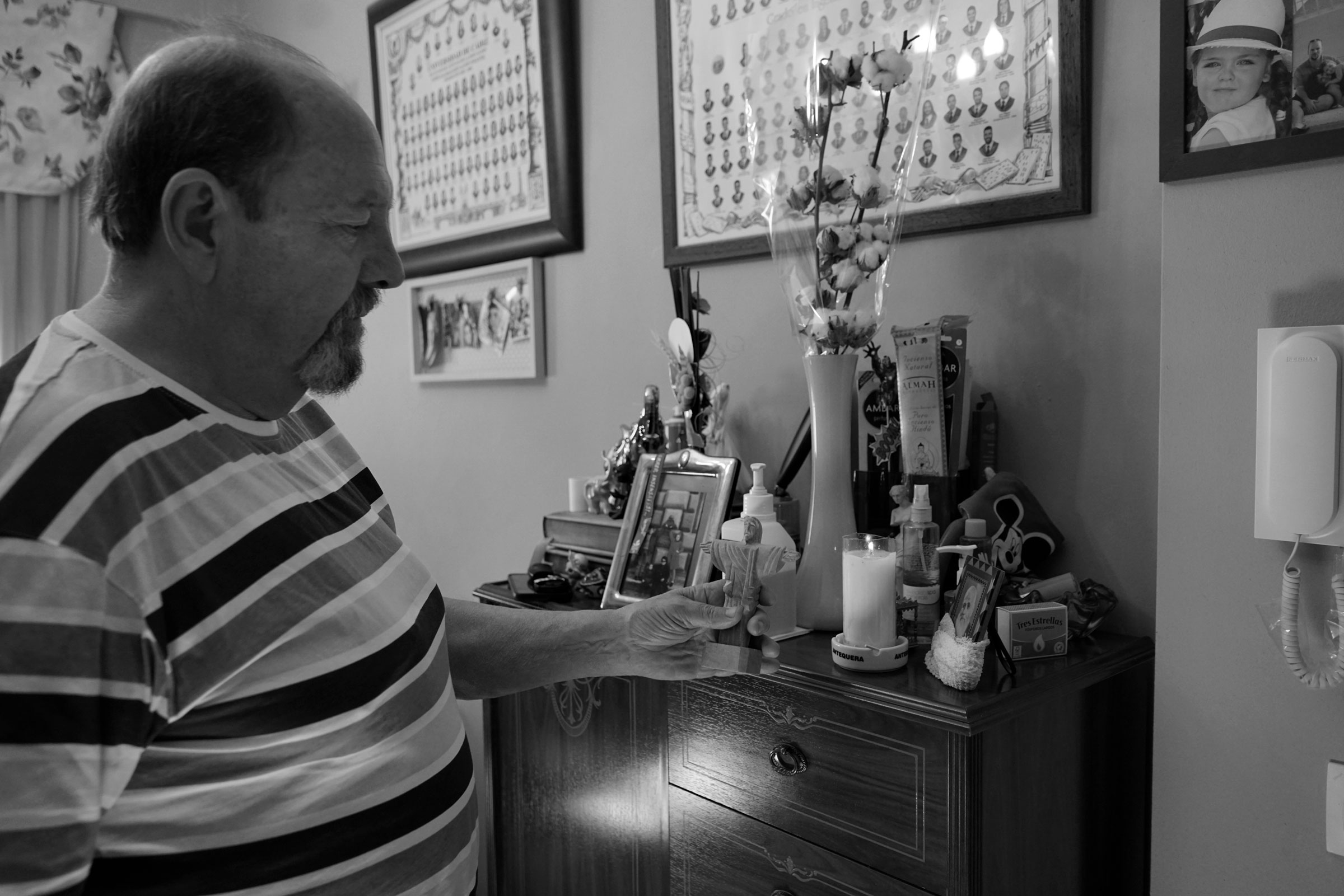 Enrique, 67 años. Mira y muestra recuerdos de sus viajes. Cuando sus riñones funcionaban y no dependía de la diálisis, le gustaba viajar. Ahora con las limitaciones de depender de una máquina y los dolores en sus piernas no puede hacerlo.