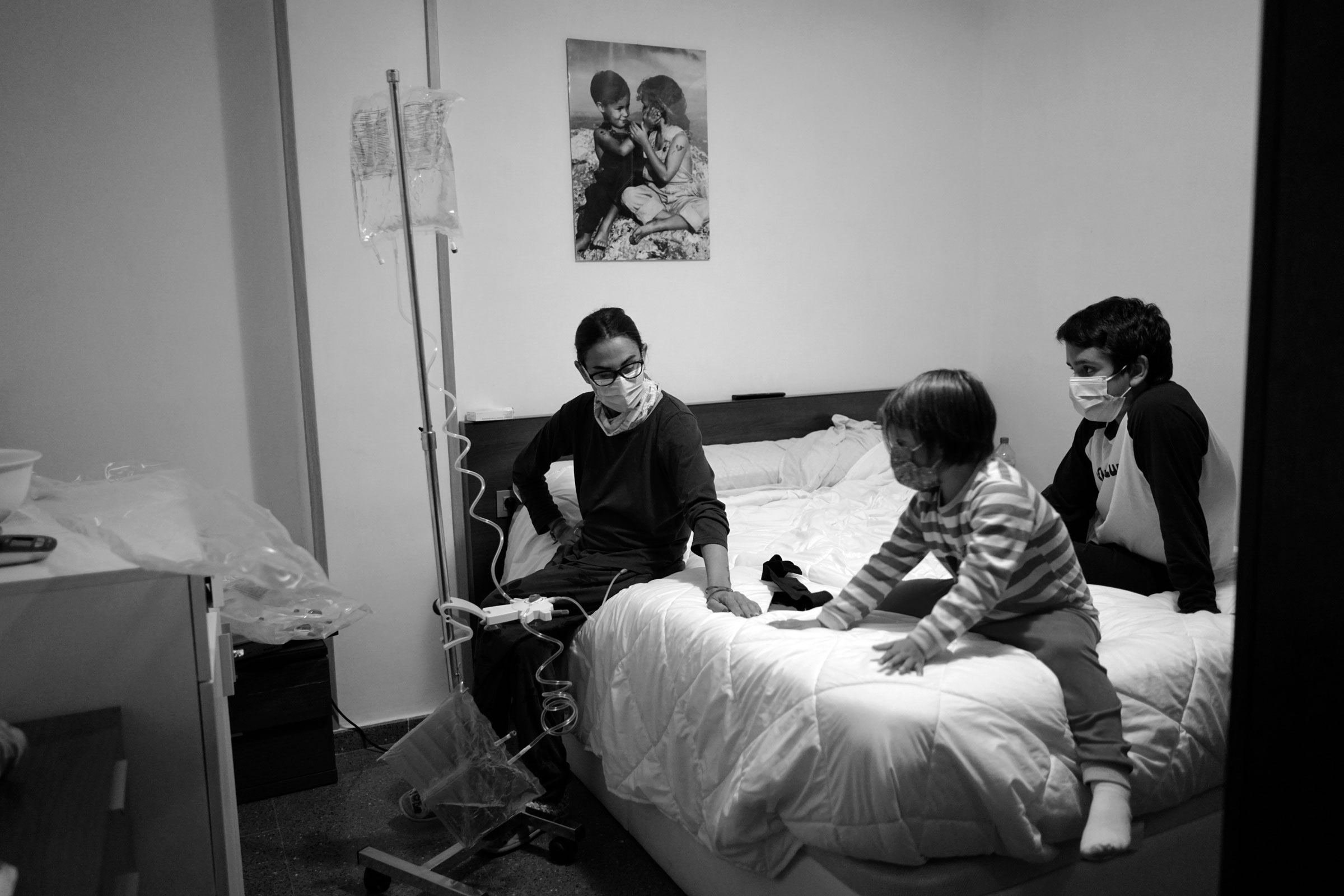 Valencia, España. Una paciente comienza una sesión de diálisis peritoneal domiciliaria, acompañada de sus hijos. Tendrá que estar toda la noche conectada a la máquina de diálisis peritoneal. Paciente dependiente del Hospital Clínico Universitario de Valencia (HCUV).